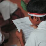 Siswa membaca lembar kertas